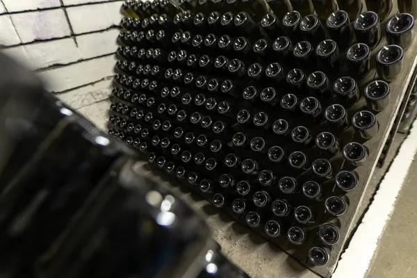 Sparkling wine bottles in the cellars of winery, sparkling wine fermenting on stands