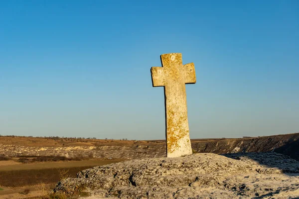Tourist attraction in Orhei, Moldova. The Old Orhei Cross in front of the old stone carved church