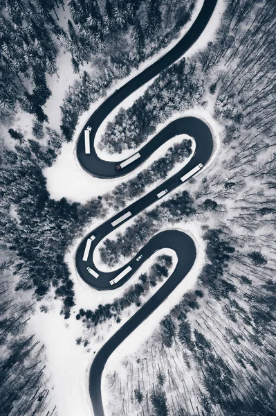 Caminhões em uma estrada sinuosa no tempo de inverno — Fotografia de Stock