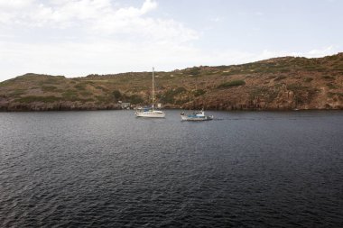 Bir plaj, kayalar ve patmos Adası, yaz Yunanistan'da ege denizde şişme bota görünümünü