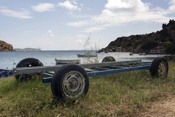A boat trailer and fishing boats in the beach in the island of Patmos, Greece in summer time