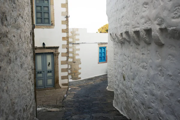 一个狭窄的街道与拱和木门窗与白色墙壁石头建筑学海岛帕特莫斯 — 图库照片