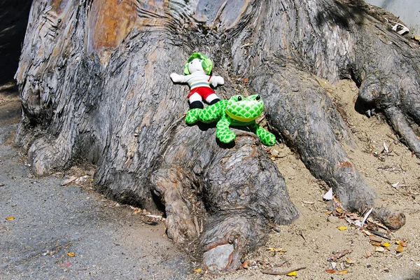 Two inflatable toys on the root of an huge old tree