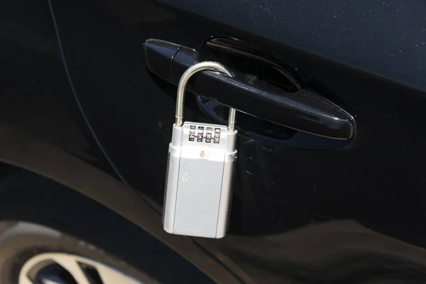 A close up view of a lock box on the car\'s door