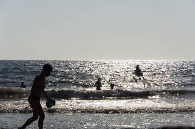 İnsanların oynamak, dalgalar Patmos, Yunanistan adada yaz aylarında yüzme silüeti