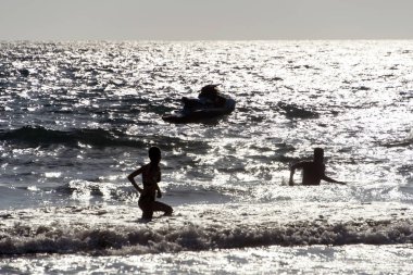 İnsanların oynamak, dalgalar Patmos, Yunanistan adada yaz aylarında yüzme silüeti