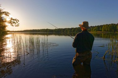 balıkçı batan güneşin ışınları
