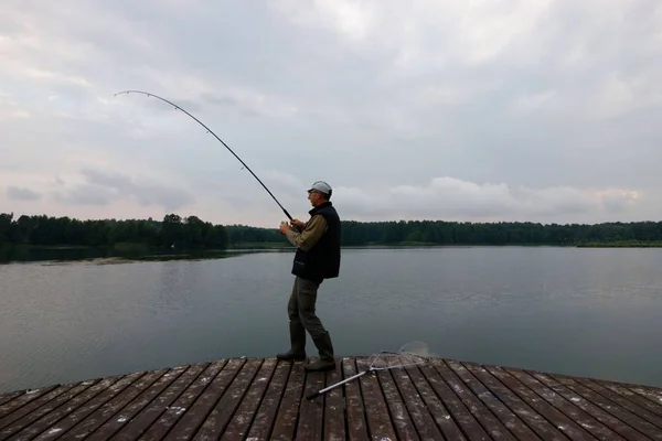 Fisker Som Fanger Fisken Fra Trepaier Skyet – stockfoto