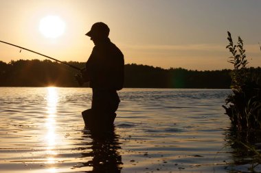 Gündoğumu sırasında balık yakalamak balıkçı silüeti
