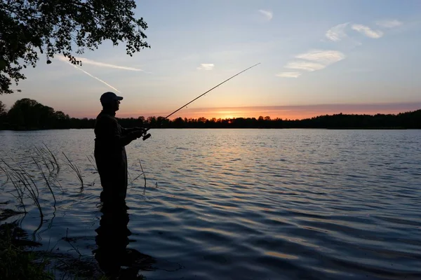 Силуэт Рыбака Стоящего Озере Ловившего Рыбу Закате — стоковое фото