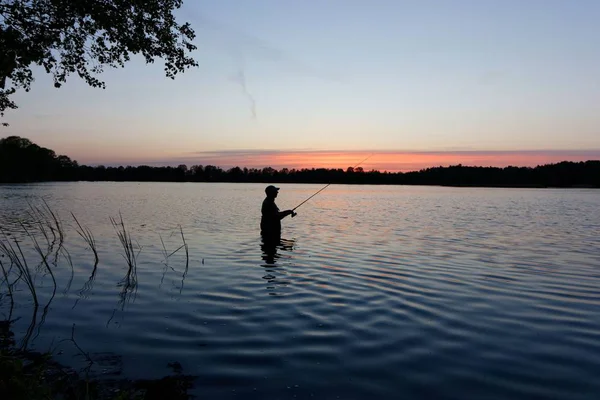 Silhouette Pescatore Piedi Nel Lago Cattura Dei Pesci Durante Tramonto — Foto Stock