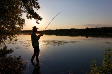 Balıkçılar gün batımında balık yakalıyor.