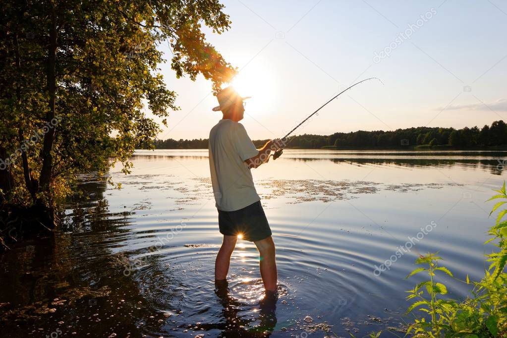 Fisherman in the rays of the setting sun