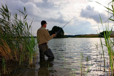 Balıkçı fırtınalı havada balık yakalar.