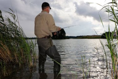 Balıkçı fırtınalı havada balık yakalar.