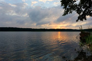 Bir gölde bulutlu gündoğumu sırasında görüntülemek