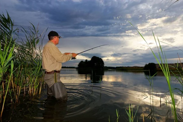 Pescador Captura Peixe Durante Pôr Sol Nublado — Fotografia de Stock