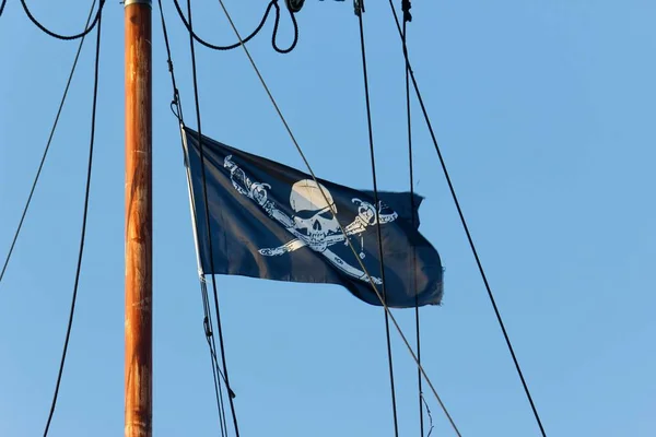 pirate flag at the mast on blue sky