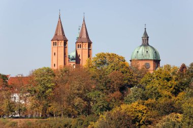 Cathedral towers amidst autumnal trees, Tumskie Hill in Plock, Poland clipart