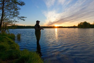 Fener günbatımı sırasında balık yakalamak