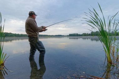 Balıkçı bulutlu bir günde balık yakalıyor.