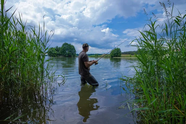 嵐の中釣り人が魚を捕まえる — ストック写真