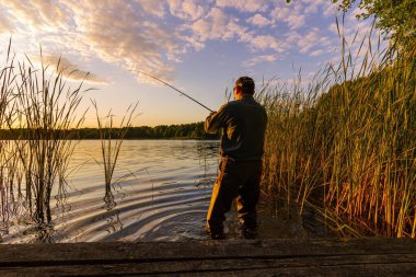 Balıkçılar gün batımında balık yakalıyor.