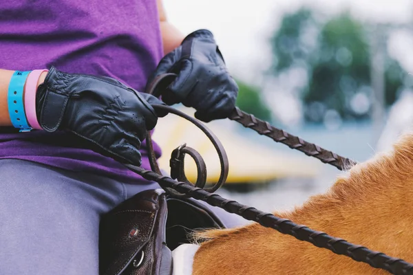 Nahaufnahme von Lederhandschuhen und Zügeln bei Pferdeschau. — Stockfoto