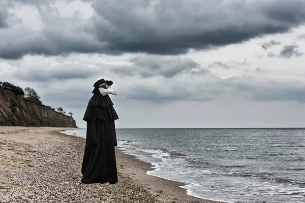 在海边的瘟疫医生 背景有戏剧性天空的户外肖像 — 图库照片