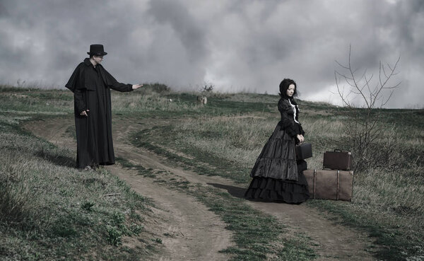 Outdoors portrait of a victorian lady in black and gentleman tal