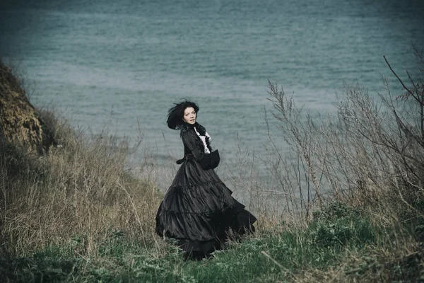 Outdoors portrait of a victorian lady in black. Run away and tur — Stock Photo, Image