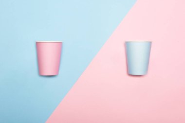 Nane mavisi ve pembe kağıt içme bardak duotone pembe ve mavi arka plan üzerinde. Doğum günü partisi kutlama soyut moda bebek duş konsepti.