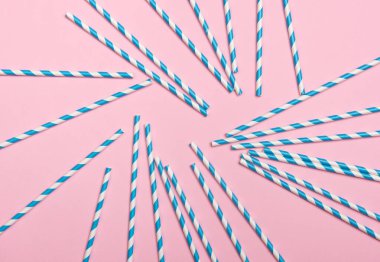 Pembe arka planda çizgili koktail pipetler. Doğum günü partisi kutlama soyut moda bebek duş kavramı. Minimalist pastel tarzı.