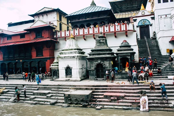 Katmandu Nepal 27 Ağustos 2018 dini bir tören katılıyor ve bir ceset yakma önce hazırlama bilinmeyenli Hindu insanların görünümünü ön nehrin Pashupatinath Tapınağı'nda öğleden sonra