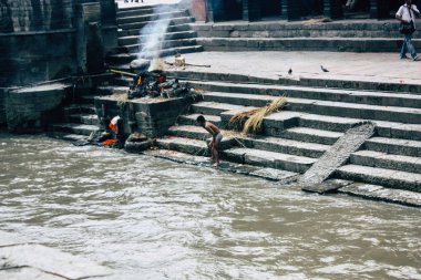 Katmandu Nepal 27 Ağustos 2018 bilinmeyen Nepalce çocuk ölü yakma ön nehre nehir Pashupatinath Tapınağı öğleden sonra banyo görünümünü