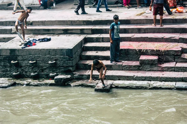 加德满都尼泊尔2018年8月27日在帕斯帕提那寺的河边的火葬前 在河边洗澡的尼泊尔孩子的视线 — 图库照片