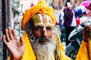 Katmandu Nepal 1 Eylül 2018 bir Sadhu ile boya portresi nokta Kathmandu Durbar Meydanı'nda sabah oturan yüz ve sarı giysiler