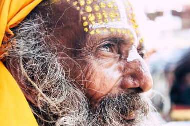 Katmandu Nepal 1 Eylül 2018 bir Sadhu ile boya portresi nokta Kathmandu Durbar Meydanı'nda sabah oturan yüz ve sarı giysiler