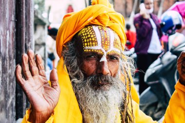 Katmandu Nepal 1 Eylül 2018 bir Sadhu ile boya portresi nokta Kathmandu Durbar Meydanı'nda sabah oturan yüz ve sarı giysiler
