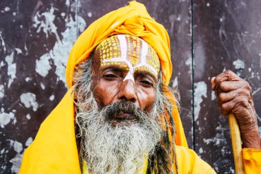 Katmandu Nepal 1 Eylül 2018 bir Sadhu ile boya portresi nokta Kathmandu Durbar Meydanı'nda sabah oturan yüz ve sarı giysiler