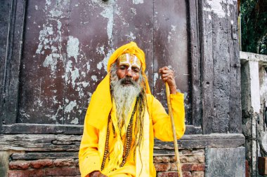 Katmandu Nepal 1 Eylül 2018 bir Sadhu ile boya portresi nokta Kathmandu Durbar Meydanı'nda sabah oturan yüz ve sarı giysiler