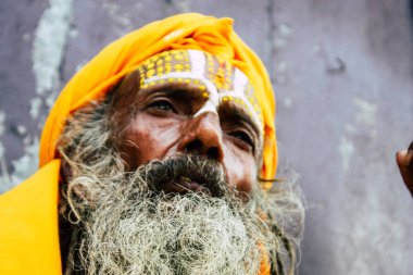 Katmandu Nepal 1 Eylül 2018 bir Sadhu ile boya portresi nokta Kathmandu Durbar Meydanı'nda sabah oturan yüz ve sarı giysiler