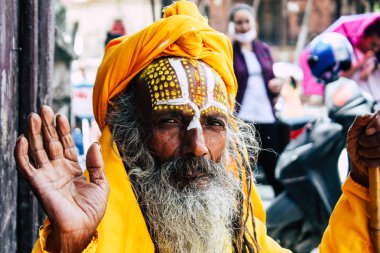 Katmandu Nepal 1 Eylül 2018 bir Sadhu ile boya portresi nokta Kathmandu Durbar Meydanı'nda sabah oturan yüz ve sarı giysiler