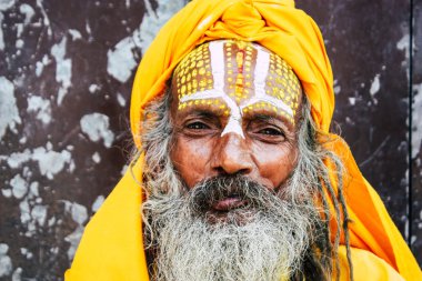 Katmandu Nepal 1 Eylül 2018 bir Sadhu ile boya portresi nokta Kathmandu Durbar Meydanı'nda sabah oturan yüz ve sarı giysiler