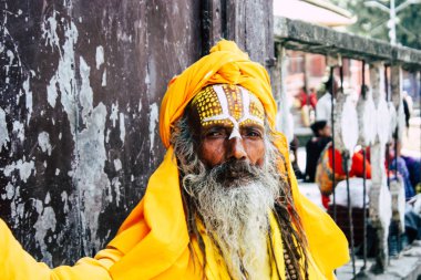 Katmandu Nepal 1 Eylül 2018 bir Sadhu ile boya portresi nokta Kathmandu Durbar Meydanı'nda sabah oturan yüz ve sarı giysiler
