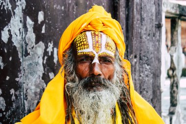Katmandu Nepal 1 Eylül 2018 bir Sadhu ile boya portresi nokta Kathmandu Durbar Meydanı'nda sabah oturan yüz ve sarı giysiler