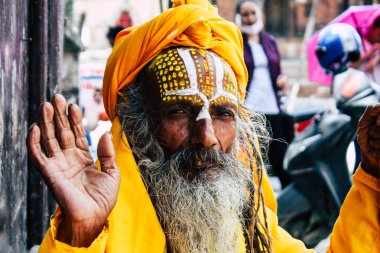 Katmandu Nepal 1 Eylül 2018 bir Sadhu ile boya portresi nokta Kathmandu Durbar Meydanı'nda sabah oturan yüz ve sarı giysiler