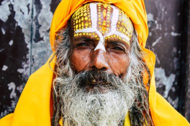 Katmandu Nepal 1 Eylül 2018 bir Sadhu ile boya portresi nokta Kathmandu Durbar Meydanı'nda sabah oturan yüz ve sarı giysiler