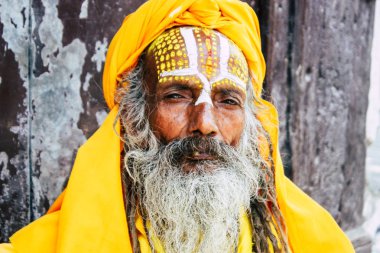 Katmandu Nepal 1 Eylül 2018 bir Sadhu ile boya portresi nokta Kathmandu Durbar Meydanı'nda sabah oturan yüz ve sarı giysiler