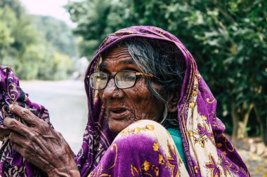 : Lumbini Nepal 3 Kasım 2018: Lumbini Kutsal buda bahçede girişte öğleden sonra oturan bilinmeyen Nepal yaşlı kadın görünümünü